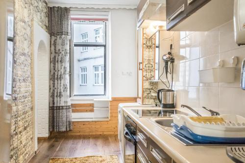 eine kleine Küche mit einem Waschbecken und einem Fenster in der Unterkunft Adorable 2BR Apt. near Millenium Tower and Danube in Wien