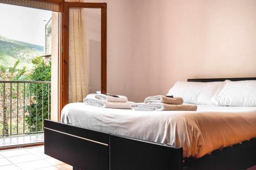 a bedroom with a bed with a large window at Ca La Valls - Casa céntrica ideal para familias in Tortellá