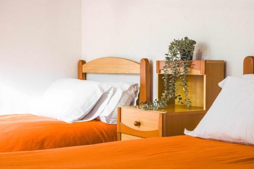 a bedroom with two beds and a dresser with a bed sqor at Ca La Valls - Casa céntrica ideal para familias in Tortellá