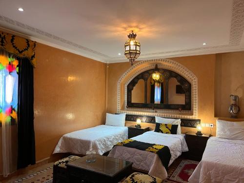 una camera d'albergo con due letti e uno specchio di Riad Ritaj a Meknès