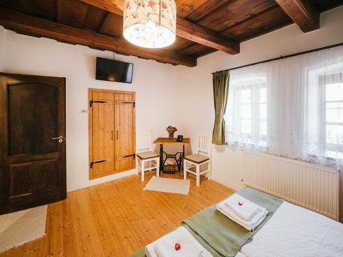 a room with a bed and a table and a door at A MI KISHÁZUNK vendégház in Szomód