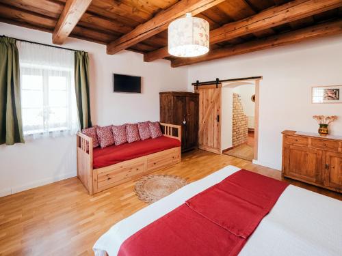 a bedroom with a bed and a couch in a room at A MI KISHÁZUNK vendégház in Szomód
