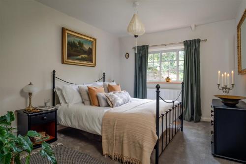 a bedroom with a bed and a window at The Stables - Charming 15th-century rural bolthole in Newton Abbot