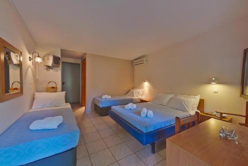 a hotel room with two beds and a table at Olympios Zeus in Plaka Litochorou
