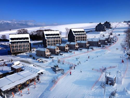 a group of buildings in the snow with people at Demänová Rezort in Liptovský Mikuláš