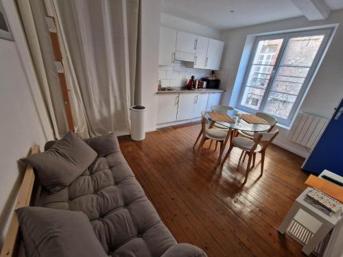una sala de estar con un sofá y una mesa en Le Voilier, en Dieppe