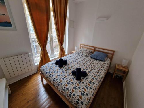 Un dormitorio con una cama con cruces negras. en Le Voilier, en Dieppe