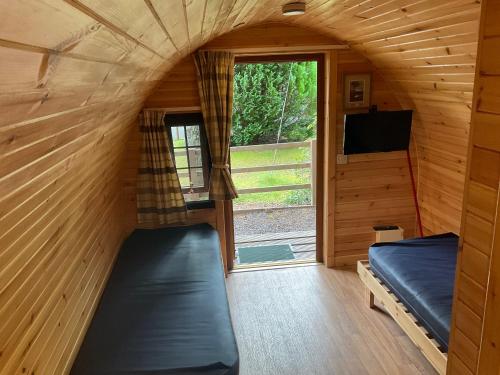 a room with two bunk beds in a tiny house at Glamping Hut - By The Way Campsite in Tyndrum