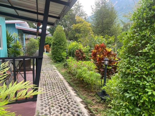 a garden with a walkway next to a house at ทับศิลารีสอร์ท Tubsila Resort in Chongsadao