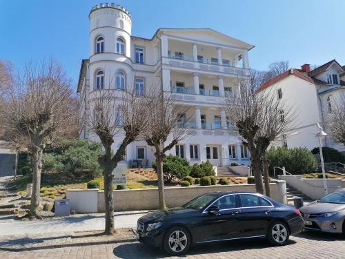 ein schwarzes Auto, das vor einem Gebäude parkt in der Unterkunft Apartment AMAPOLA - Villa Odin in Ostseebad Sellin