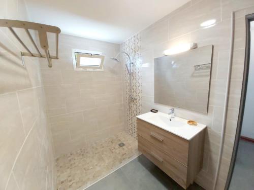 ein weißes Badezimmer mit einem Waschbecken und einem Spiegel in der Unterkunft La Casa Emy in Saint-Leu