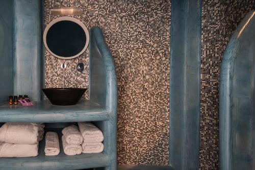 a bathroom with a sink and a mirror and towels at Kasimatis by La Perla - Adults Only in Imerovigli