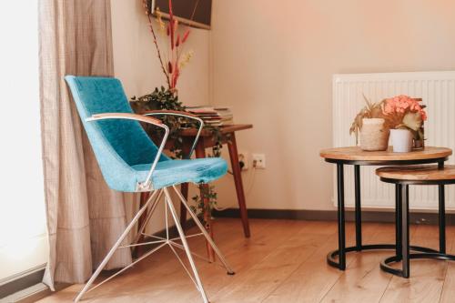 HOLT Hotel في نايميخن: كرسي ازرق وطاولة في الغرفة