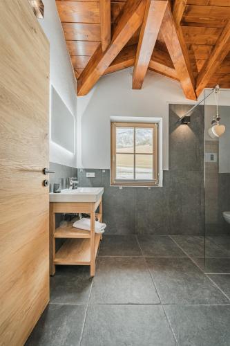 a bathroom with a sink and a glass shower at Dachstein West Apartment T5 in Russbach am Pass Gschütt