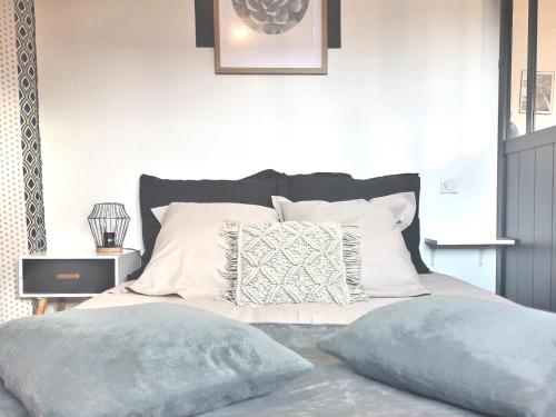 1 dormitorio con 1 cama con 2 almohadas en Cosy flat proche Gare & Parking - clim, en Agen