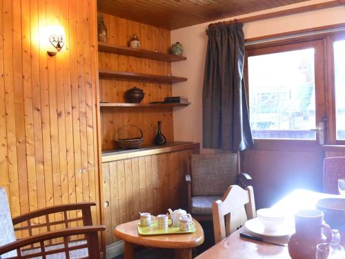 une salle à manger avec une table et des chaises et une fenêtre dans l'établissement Appartement cozy à Méribel, 6 pers, proche pistes, commerces et navette, cheminée, balcon sud. - FR-1-180-160, à Méribel