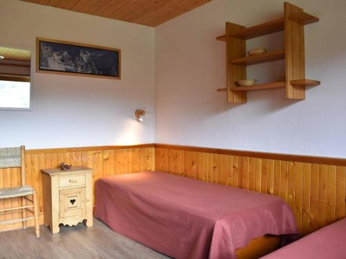 - une chambre avec un lit, une table et une étagère dans l'établissement Appartement cozy à Méribel, 6 pers, proche pistes, commerces et navette, cheminée, balcon sud. - FR-1-180-160, à Méribel