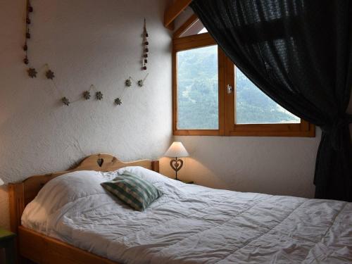 a bedroom with a bed with a window and a pillow at Appartement Méribel, 5 pièces, 8 personnes - FR-1-180-186 in Méribel