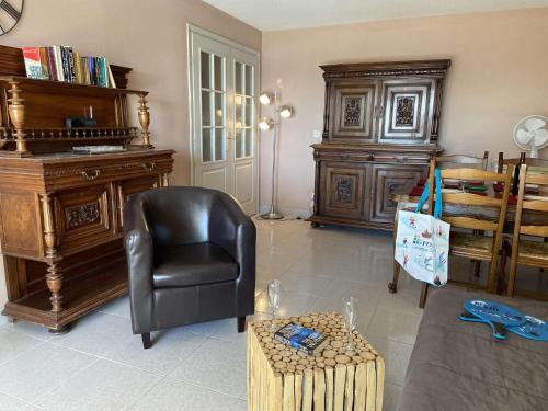 - un salon avec une chaise et un piano dans l'établissement Appartement 2 pièces avec terrasse et parking, proche thalassothérapie - FR-1-226A-29, à Fréjus