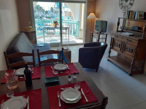 un salon avec une table, des chaises et une télévision dans l'établissement Appartement 2 pièces avec terrasse et parking, proche thalassothérapie - FR-1-226A-29, à Fréjus
