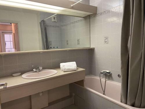 une salle de bain avec un lavabo, un miroir et une baignoire dans l'établissement Appartement 2 pièces avec terrasse et parking, proche thalassothérapie - FR-1-226A-29, à Fréjus