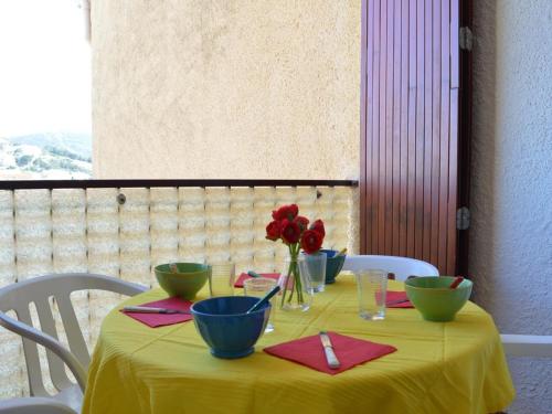 une table avec un chiffon de table jaune et des fleurs sur elle dans l'établissement Studio cabine avec clim, parking et loggia - Banyuls-sur-Mer - FR-1-225C-260, à Banyuls-sur-Mer