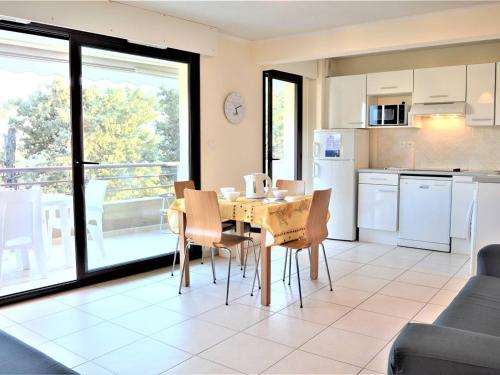 une cuisine et une salle à manger avec une table et des chaises dans l'établissement Appartement T3 lumineux avec terrasse, climatisation, garage et Wifi à 2 pas des plages - Cavalaire - FR-1-226B-34, à Cavalaire-sur-Mer