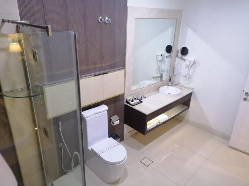 a bathroom with a toilet and a sink and a mirror at Olian Hotel in Riyadh