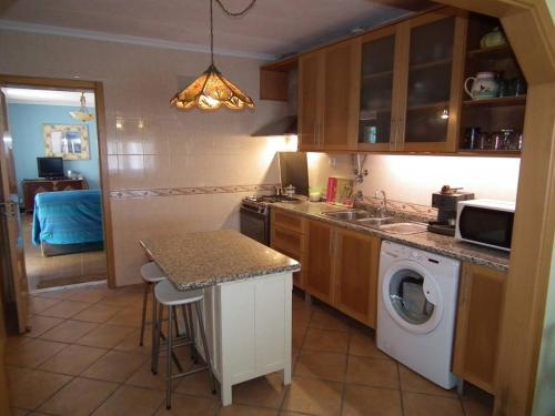 cocina con fregadero y lavadora en West Terrace House - Ocean View, en Lourinhã