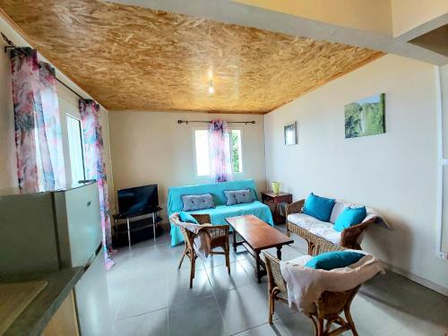 a living room with a blue couch and chairs at La Casa Emy in Saint-Leu