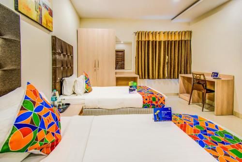 a hotel room with two beds and a desk at Fabhotel Pearl City - Nr Jubilee Enclave, Hitech City in Hyderabad