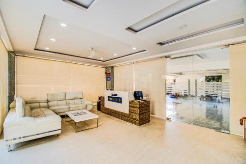 - un salon avec un canapé et une télévision dans l'établissement FabHotel Pearl City HiTech City, à Hyderabad