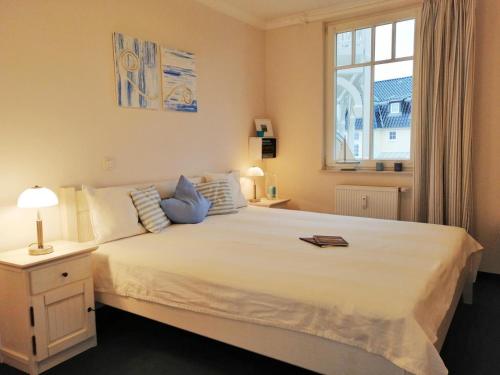 - une chambre avec un grand lit blanc et une fenêtre dans l'établissement Residenz Ostseestrand, à Kühlungsborn