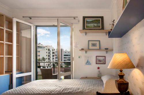 sypialnia z łóżkiem i dużym oknem w obiekcie Seaside Escape w Funchal