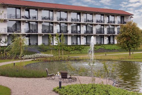 a hotel with a fountain in front of a building at Van der Valk Hotel Melle - Osnabrück in Melle