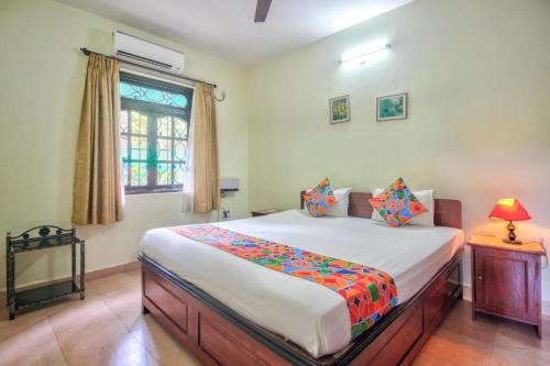 1 dormitorio con cama y ventana en Goa Garden Resort - Sandray Apartments & Villa at Benaulim - Colva beach, en Colva