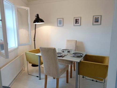 comedor con mesa, sillas y lámpara en 2 Bed Functional House Close to Manor Park Train Station en Londres