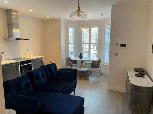 a living room with a blue couch and a table at Boutique Luxury Apartment, High St, Henley-in-Arden in Henley in Arden