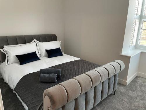a bedroom with a large bed with blue pillows at Boutique Luxury Apartment, High St, Henley-in-Arden in Henley in Arden