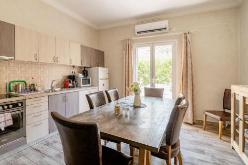 a kitchen with a wooden table and chairs in a kitchen at Amazing House with Jacuzzi and Huge PVT Garden in Athens