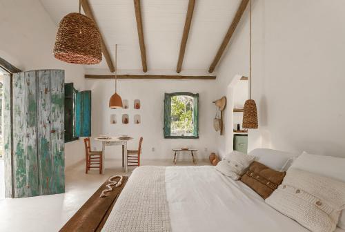 sypialnia z dużym łóżkiem i stołem w obiekcie Vila Oyá - praia de algodões w mieście Maraú