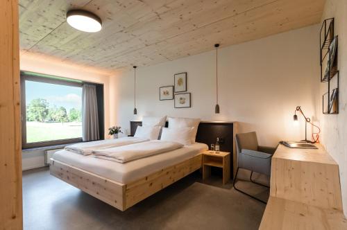 ein Schlafzimmer mit einem großen Bett und einem Fenster in der Unterkunft Allgäuer Genusshotel und Historischer Brauereigasthof Hirsch in Leutkirch im Allgäu