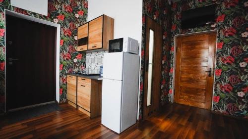 a kitchen with a white refrigerator in a room at WOKU Studio - apartament in Świebodzice