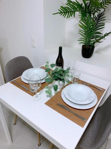 a white table with plates and glasses on it at The Hidden Studio; Comfy & close to the Lake in Lugano