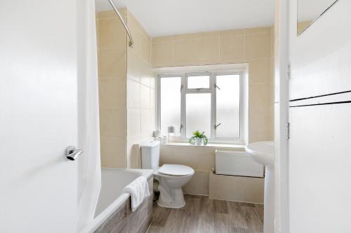 a white bathroom with a toilet and a sink at Brambles House West Drayton 3 Bedroom House with parking By MDPS in West Drayton