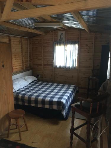 a bedroom with a bed in a log cabin at Suikerbekkie Bos in Baardskeerdersbos