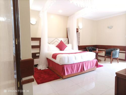 a bedroom with a bed and a table and chairs at Meru Slopes Hotel in Meru