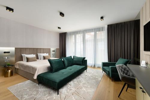 a bedroom with a bed and a green couch at Emerald Downtown Luxury Suites by Continental Group in Budapest