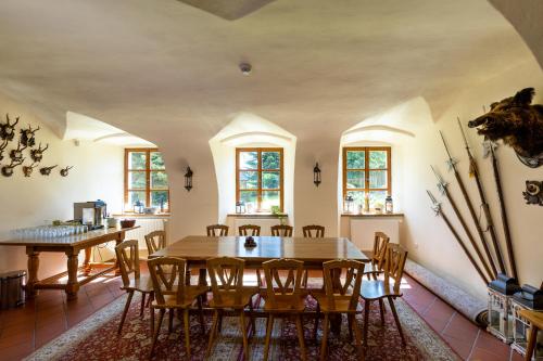Un comedor con mesa y sillas de madera. en Zámeček Klokočov, en Klokočov