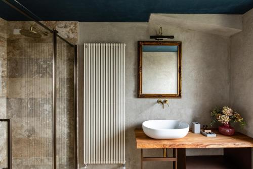 a bathroom with a sink and a mirror and a shower at Country House Oliveto sul Lago in San Nicolò